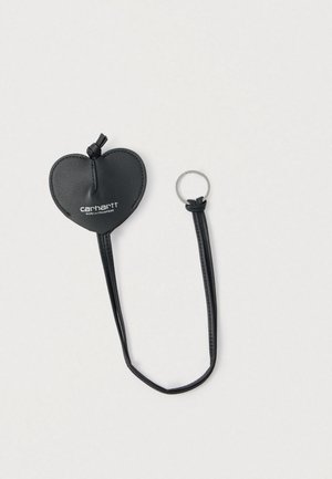 Czarny skórzany brelok w kształcie serca z pętlą i srebrnym kółkiem na klucze, z detalami przeszyć i logo z przodu.