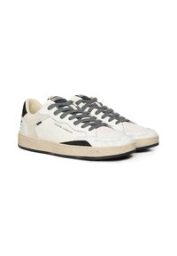Sneakers in pelle bianca con lacci grigi, accenti neri sul tallone, una punta strutturata e una suola color crema. Logo visibile sulla linguetta.
