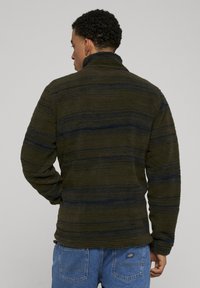 Fleecegenser i mørkegrønn med marineblå striper, med høy krage og strukturert stoff. Ledig passform med lange ermer og elastiske mansjetter.