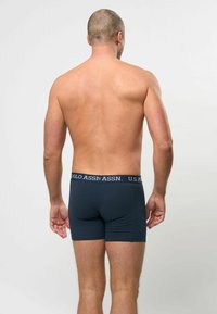 Marineblå herre boxershorts laget av myk stoff, med et merkevare-elastisk liv. Designet gir en tett passform uten synlige mønstre.