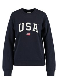 Mörkblå sweatshirt i bomull med "USA" tydligt i vita bokstäver och en liten amerikansk flagga under. Långa ärmar och ribbad nederkant.