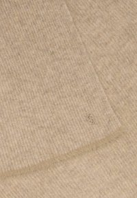 Écharpe en laine beige avec une texture côtelée, des bords frangés doux et un petit logo dans le coin inférieur droit.