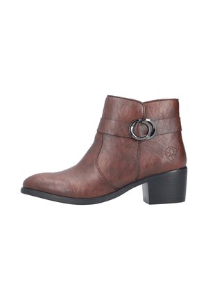 Bottine en cuir marron avec petit talon bloc, bride décorative avec deux anneaux argentés et logo embossé sur le côté extérieur.
