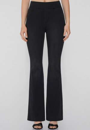Pantaloni flair in denim nero con una texture liscia, dotati di una vita alta, tasche frontali e dettagli di cucitura.
