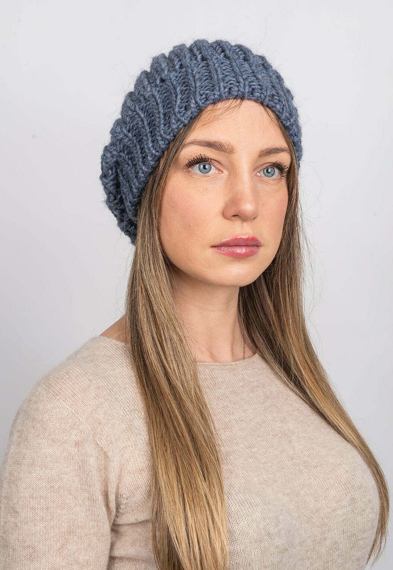Šedý pletený beanie s žebrovanou strukturou, nabízí oversized střih. Hladká látka a ležérní design, vhodné pro různé venkovní aktivity.