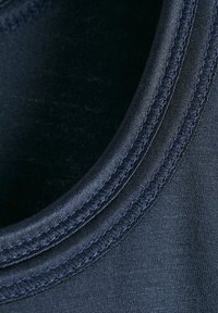 Tessuto blu navy con una trama liscia, caratterizzato da un colletto rotondo e cuciture piatte. Il design è minimalista, senza modelli o accenti visibili.