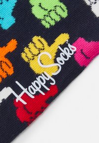 Colorful cotton socks feature a navy background with multi-colored hand prints in red, orange, yellow, green, turquoise, and pink, labeled "Happy Socks."
