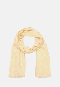 Écharpe beige clair en tissu doux, présentant un motif ton sur ton subtil, finie avec des franges à chaque extrémité.