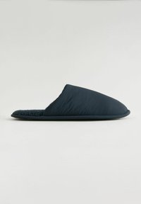 Chausson bleu marine avec un upper rembourré, doublure en polaire texturée et semelle en caoutchouc flexible. Design simple, surface lisse et bout fermé.