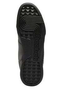 Semelle noire de sneaker Reebok avec une adhérence texturée, des lignes courbes près des orteils et le nom de la marque Reebok embossé le long de la voûte.