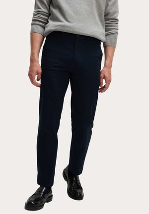 Pantalones azules marinos de corte ajustado, confeccionados con una mezcla de algodón, textura suave, con bolsillos laterales y cierre con cremallera.