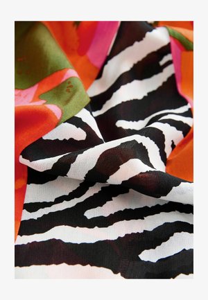 Colorful fabric featuring a bold zebra stripe pattern in black and white, combined with vibrant floral shapes in pink, orange, and green.