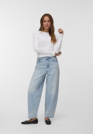 Hvit langermet topp, lys blå vide jeans og svarte leiligheter; glatt stoff, løs passform, minimalistisk design, nøytrale farger.