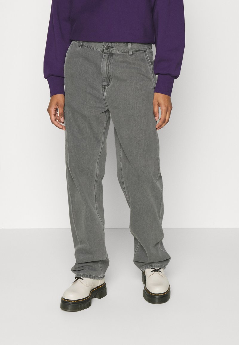 Grey denim jeans with a relaxed fit, featuring a classic five-pocket design, belt loops, and a subtle faded texture. Paired with off-white shoes.