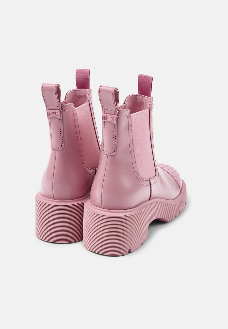 Bottines Chelsea en cuir rose avec panneaux élastiques sur les côtés, une semelle plateforme texturée et une languette à l'arrière pour un enfilage facile.
