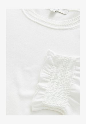 T-shirt blanc avec un détail texturé et froncé sur la manche. Encolure côtelée épaisse et tissu lisse. Design simple, sans motifs ni accents.
