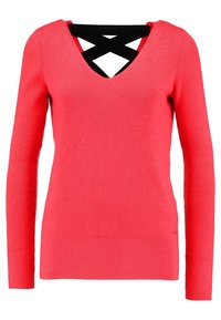 Sweter z dekoltem w serek, z długim rękawem, w jasnym koralowym kolorze, o prążkowanej fakturze, z czarnym krzyżującym się akcentem na plecach i dopasowanym kroju.