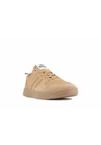 Zapatillas color tostado con parte superior de gamuza texturizada, puntera redonda y suela de goma plana. Presentan tres rayas laterales y un logo en la lengüeta.