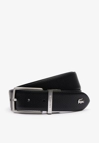 Cinturón de cuero negro con textura perforada, hebilla de metal plateado y grabado "LACOSTE" en la correa. Acabado suave, forma rectangular.