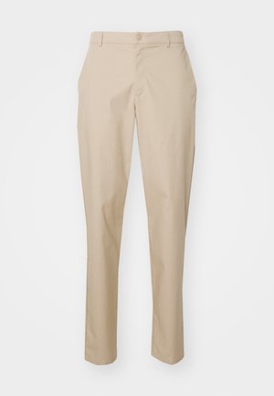 Pantalons beiges ajustés avec une coupe droite, fermeture à bouton et taille plate. Fabriqués dans un tissu lisse sans motifs visibles.