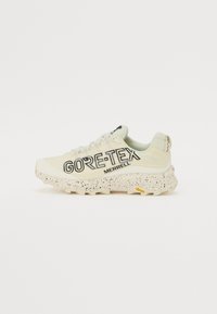 GORE-TEX Merrell sneakers i lys krem med en teksturert overdel, svart logo og flekket hvit såle med gule accenter.
