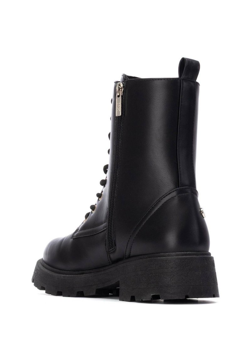 Bottes noires en cuir pour la cheville avec une semelle en caoutchouc épaisse, fermeture éclair sur le côté, lacets à l'avant et finition texturée. Talon renforcé et tirette.