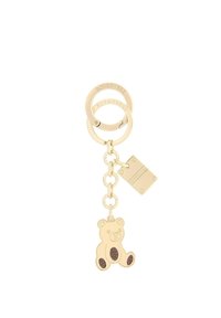 Portachiavi in metallo dorato con due anelli interconnessi, un ciondolo a forma di orso con dettagli marroni e un'etichetta rettangolare con testo in rilievo.