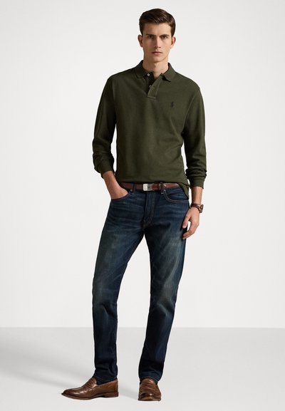 Tricou polo verde închis cu mânecă lungă și trei butoane, asortat cu blugi negri și pantofi din piele maronie. Include o curea și un ceas maro.