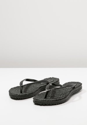 Een paar zwarte, gestructureerde teenslippers met eenvoudige Y-vormige bandjes op een effen witte ondergrond.