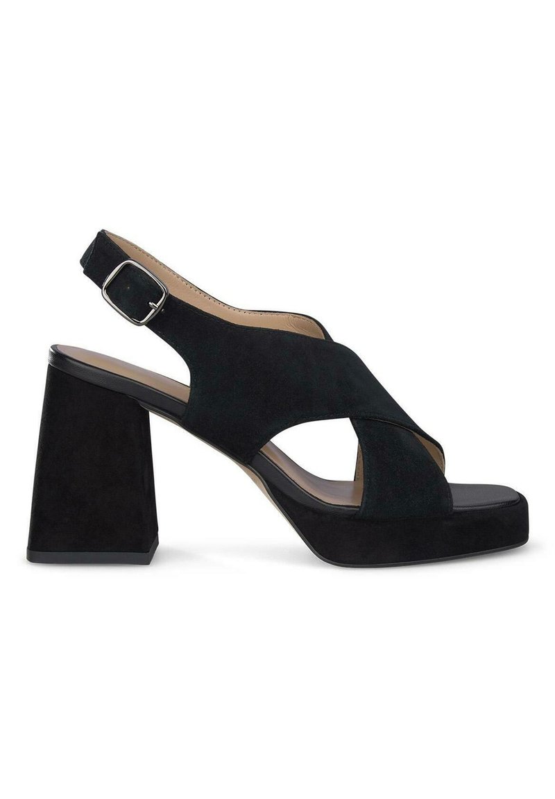 Sandales à talons en suède noir avec un large talon bloc. Elles présentent un bout ouvert, un design croisé et une bride de cheville réglable avec une boucle en argent.