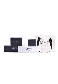 Scatole regalo bianche e nere con il logo "MYC PARIS", di diverse dimensioni, con una texture opaca, e una borsa da shopping con manici neri.