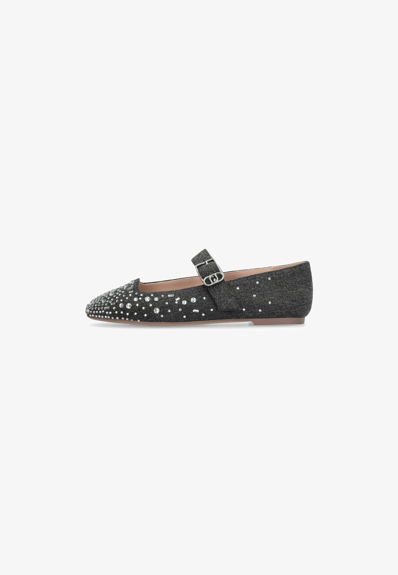 Chaussure plate Mary Jane noire avec une boucle argentée et des clous décoratifs argentés sur le bout et les côtés.