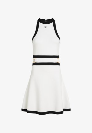 Valge kleit, millel on laienev seelik, mustad aktsendid kaeluses ja vöökohtades, kaunistatud kuldsete detailidega ning sobiva, sportliku disainiga.