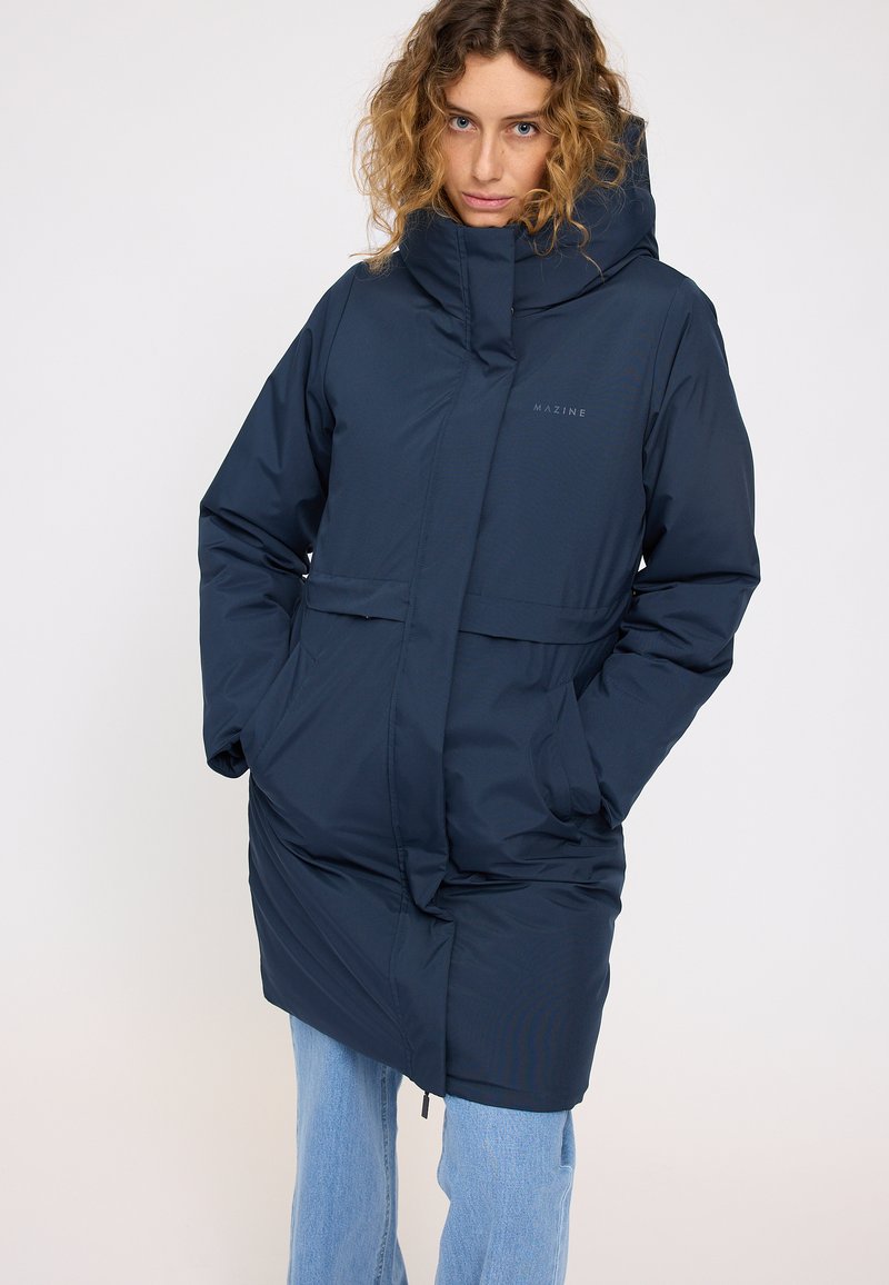 Marineblauer langer Parka mit hohem Kragen, Fronttaschen und zweigeteiltem Design; aus glattem, wasserabweisendem Material gefertigt. Mit Markenlogo.