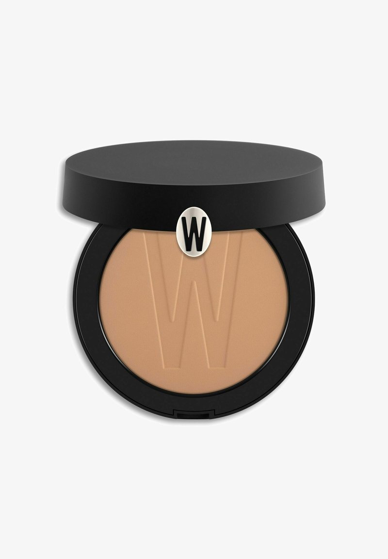 Fondotinta in polvere pressata in un astuccio rotondo nero; tonalità beige soffice con un sottile motivo in rilievo a "W" sulla superficie. Texture liscia e opaca.