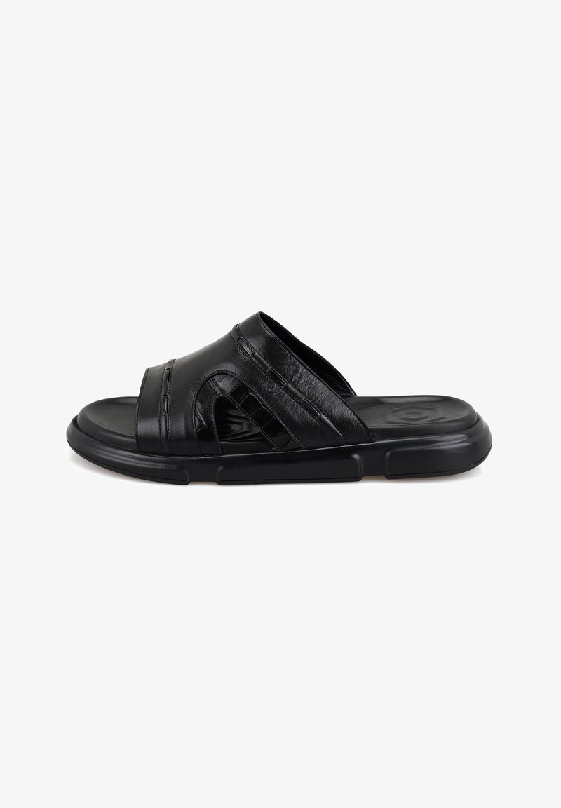 Sandale à glissière en cuir noir avec design perforé, brides texturées et semelle rembourrée. Comprend une semelle intérieure moulée et une semelle extérieure en caoutchouc flexible.