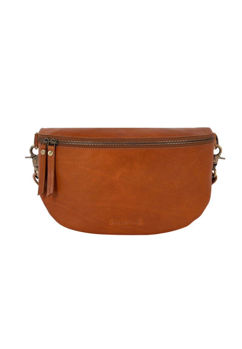 Tan leather bag with a rounded shape, a zip closure, hanging tab, and metal hardware accents. Minimalist design with a smooth texture.
