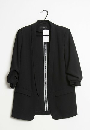 Zwarte, open voorkant blazer met geplooide mouwen en klepzakken, hangend aan een zwarte hanger tegen een witte achtergrond.