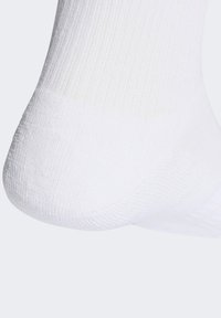 Calzino bianco alla caviglia realizzato in tessuto a coste; presenta una punta liscia e senza cuciture e un tallone rinforzato per una maggiore durata.