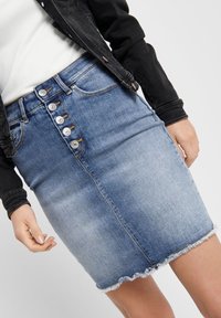 Denimkjol i ljusblått med fransat nederkant, med hög midja och fem metallknappar framtill, slät textur och inga fickor.