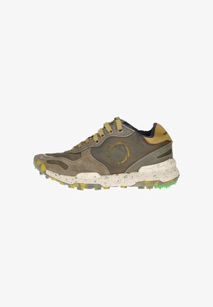 Zapatillas de ante marrón con una media suela blanca moteada, detalles amarillos y una suela texturizada. Presenta picos con puntas verdes y diseño de cordones.