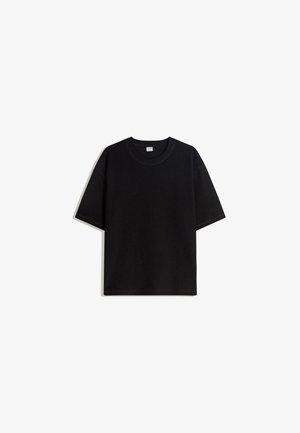 Czarny, krótki rękaw t-shirt wykonany z bawełny, z okrągłym dekoltem i luźnym, pudełkowym krojem z minimalnymi detalami szwów.