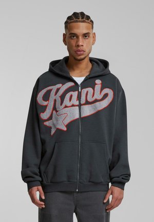 Black zip-up hoodie featuring large gray and red embroidered text "Kani" with a star accent, front pockets, and a drawstring hood.