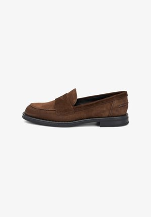 Mocasin de ante marrón con puntera redondeada, detalles cosidos, suela de goma plana y una correa ancha en la parte superior.