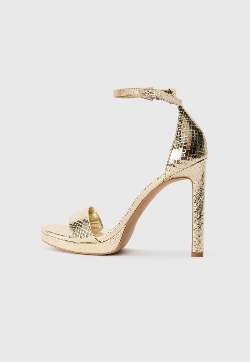 Goldfarbene High-Heel-Sandalen mit einem verstellbaren Knöchelriemen, strukturiertem Reptilmuster, offenem Zehenbereich und schlankem Profil.