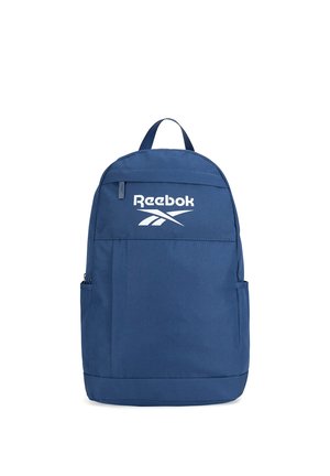 Niebieski plecak Reebok z przednią kieszenią na suwak, bocznymi kieszeniami, górnym uchwytem oraz białym logo Reebok na górnej części przedniego panelu.