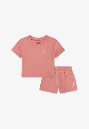 T-shirt en coton rose à manches courtes avec un logo blanc, accompagné d'un short assorti doté d'une taille élastique et d'un détail logo.