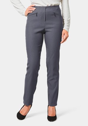 Grijze, high-waisted broek met twee ritszakken aan de voorkant, getailleerde pasvorm en een soepele stoftextuur. Gecombineerd met zwarte hakken.