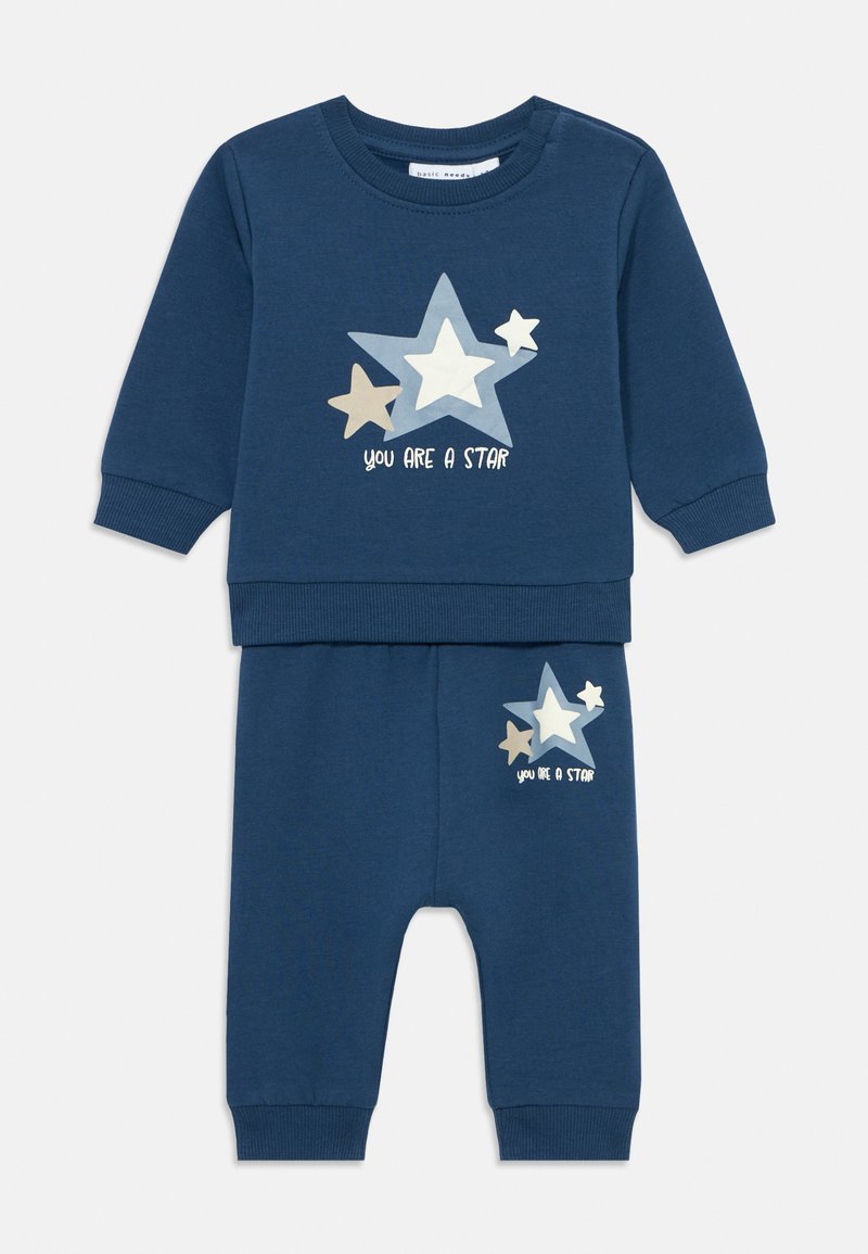 Conjunto de bebê em azul-marinho com camiseta de mangas longas e calças, decorado com três gráficos de estrelas e a frase "Você é uma estrela" no peito e na perna.