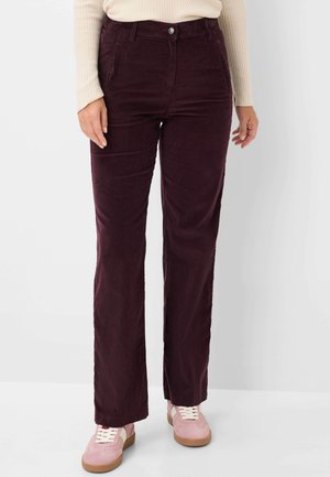Pantaloni in corduroy borgogna con design a gamba dritta, dotati di un bottone frontale, due tasche e una texture morbida, abbinati a scarpe da ginnastica rosa.